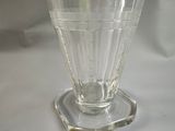 a glass vase with a silver lid sitting on a table