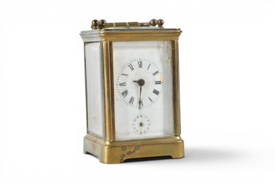 a small gold clock with roman numerals on it