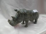 une statue représentant un rhinocéros debout sur un tissu blanc