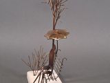 a sculpture of a bird sitting on top of a tree