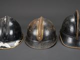 three helmets are lined up in a row on a gray surface