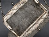 an antique silver mesh purse with a chain around it