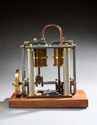 une image représentant une maquette de machine à vapeur posée sur un socle en bois