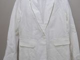 La veste blanche est suspendue à un cintre accroché au mur.