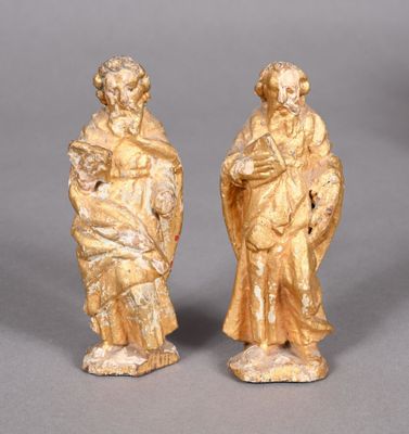pair of carved figurines of a man and a woman holding a child