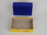 a blue box with a yellow lid sitting on top of a white table