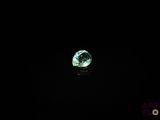 gros plan d'un diamant vert sur une surface noire