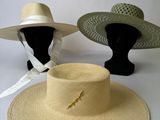 two hats are sitting on top of each other on a white surface