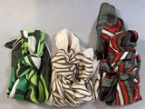 four different colored scarves are lined up on a white surface