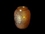 un vase en verre orné d'un motif sur fond noir