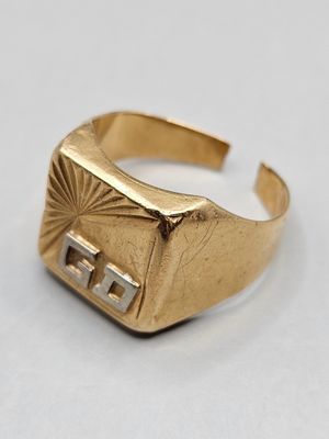 gros plan d'une bague en or sur une surface blanche