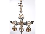 a close up of a metal cross with bells hanging from it ' s side