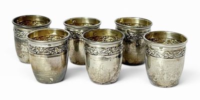 six coupes en argent sont alignées sur une surface blanche