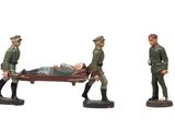 trois figurines représentant des soldats transportant un homme sur une civière