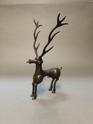 statue en bronze représentant un cerf avec des bois, sur fond blanc