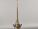 une lampe à huile ancienne en laiton, dotée d'un abat-jour en verre et posée sur un pied