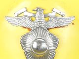 a yellow hard hat with a silver eagle emblem on it