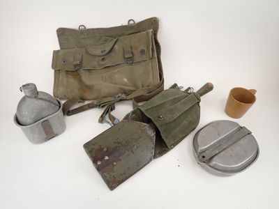 an assortment of military items including a bag, shovel, and other items