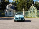 a blue car that is parked in front of a gate