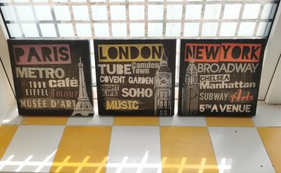 three framed posters on a window sill in front of a window
