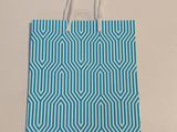 un sac de courses bleu et blanc posé sur une surface blanche