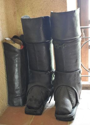 une paire de bottes noires posées sur le sol à côté d'une fenêtre