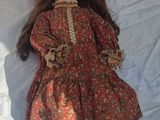 an image of a doll laying on a white sheet with a hat on