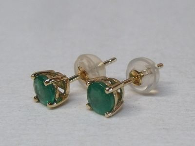 paire de boucles d'oreilles à clous ornées de pierres vertes sur fond blanc