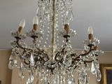 un lustre au milieu d'une pièce dont les murs sont ornés de tableaux