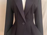 une photo d'une veste noire sur un mannequin