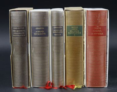 four books are lined up in a row on a black surface