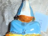 une figurine représentant une femme vêtue d'une tenue bleue et orange