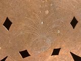 une plaque métallique percée de trous au milieu