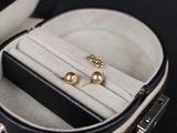 deux paires de boucles d'oreilles dans un étui posé sur une surface noire