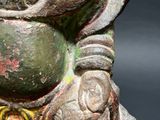 a statue of a man holding a fish on a black background
