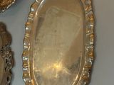 two silver trays and a silver spoon on a table
