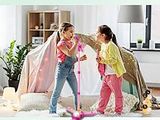 two young girls playing with a scooter in the living room