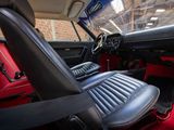 the interior of a car with red carpeting and black leather seats