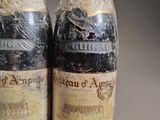 two bottles of wine wrapped in plastic on a table