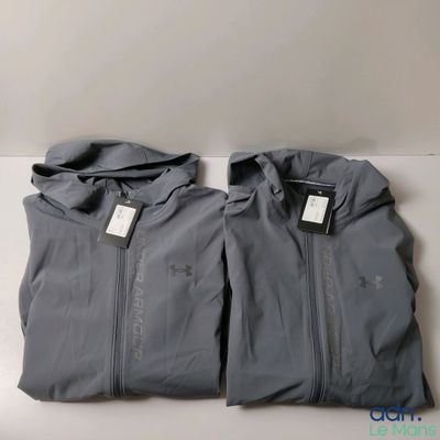 a pair of gray jackets sitting on top of a white table