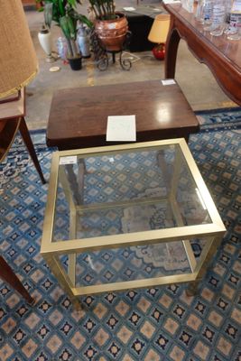 une table avec un plateau en verre sur laquelle est posée une lampe