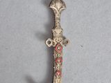 an old silver dagger with a red and white design on it