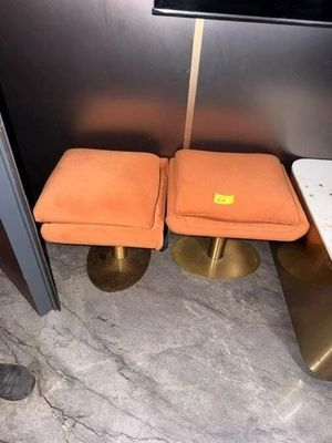 deux tabourets orange placés l'un à côté de l'autre dans une pièce