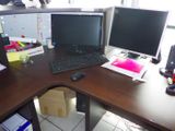 a computer desk with two monitors and a keyboard on it