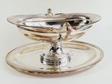 a silver plate with a bowl on top of it