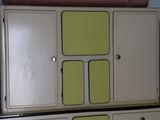 an old fashioned kitchen with green and white cupboards