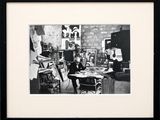 black and white photograph of a man sitting at a desk in an art studio