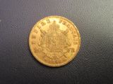 a close up of a gold coin on a black surface