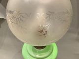 a glass vase with a bee on it sitting on a table