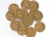 some gold coins on a white surface with a white background